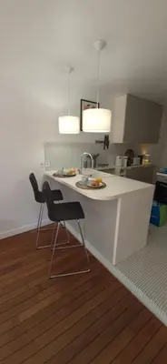 a kitchen with a white counter and two chairs at Élégant cocon sur la croisette parking terrasse et jardin in Cannes