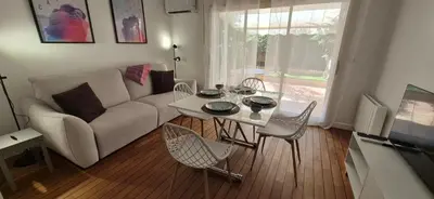 a living room with a couch and a table and chairs at Élégant cocon sur la croisette parking terrasse et jardin in Cannes