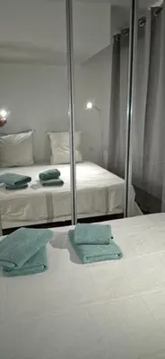 a bedroom with two beds and a mirror at Élégant cocon sur la croisette parking terrasse et jardin in Cannes