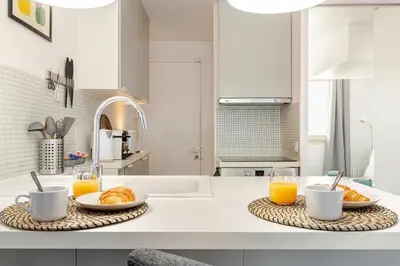 a kitchen with two plates of croissants and glasses of orange juice at Élégant cocon sur la croisette parking terrasse et jardin in Cannes