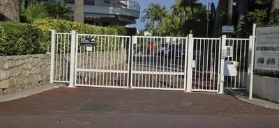 a white gate in front of a building at Élégant cocon sur la croisette parking terrasse et jardin in Cannes