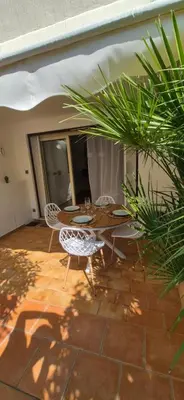 a patio with a table and chairs and a plant at Élégant cocon sur la croisette parking terrasse et jardin in Cannes