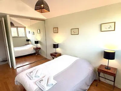 a bedroom with a bed with two towels on it at Appartement 3p vue mer proche plages et congrès in Cannes