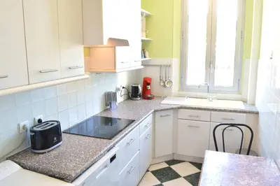 a small kitchen with white cabinets and a sink at Appartement 3p vue mer proche plages et congrès in Cannes