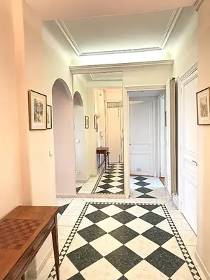 a hallway with a black and white checkered floor at Appartement 3p vue mer proche plages et congrès in Cannes