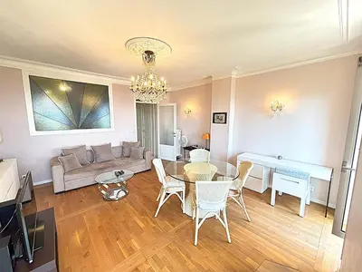 a living room with a couch and a table and chairs at Appartement 3p vue mer proche plages et congrès in Cannes