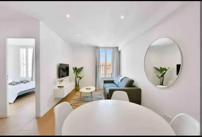 a white living room with a table and a mirror at Cannes Hoche Croisette Sublime T2 in Cannes
