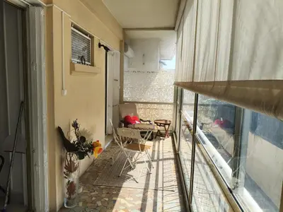a balcony with a chair and a table and a window at Studio Cannes Proche Palais des Festivals et Plages du Midi in Cannes