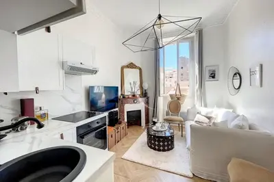 a kitchen and living room with a couch and a table at Le Barocco - Calm - Hypercentre - Cosy in Cannes