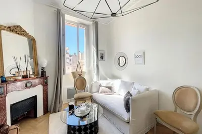 a living room with a white couch and a fireplace at Le Barocco - Calm - Hypercentre - Cosy in Cannes