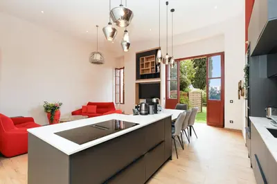 a kitchen and living room with a red couch at RARE-Superbe appt Suquet, jardin,6p,200m Croisette in Cannes