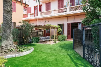 a garden with green grass in front of a building at RARE-Superbe appt Suquet, jardin,6p,200m Croisette in Cannes