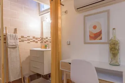a bathroom with a sink and a table and a mirror at LE MIMOSA mignon en plein centre-ville, emplacement parfait pour votre séjour in Cannes