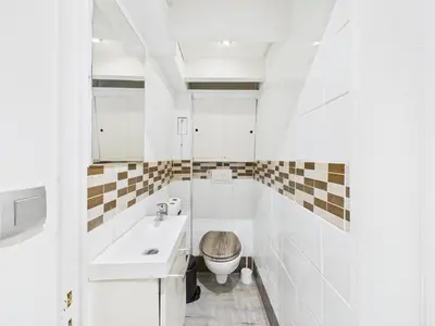 a white bathroom with a sink and a toilet at LE MIMOSA mignon en plein centre-ville, emplacement parfait pour votre séjour in Cannes
