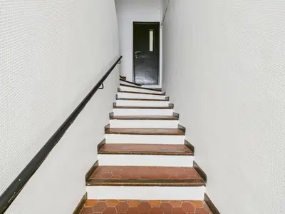 a stairway leading up to a black door at LE MIMOSA mignon en plein centre-ville, emplacement parfait pour votre séjour in Cannes