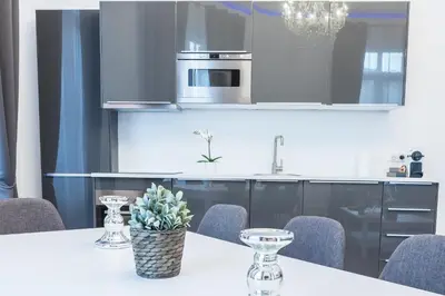 a kitchen with a white table with chairs and a stove at Residence Michel Ange in Cannes