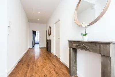 a hallway with a mirror and a wooden table at Residence Michel Ange in Cannes