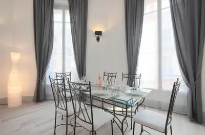 a dining room with a glass table and chairs at Residence Michel Ange in Cannes