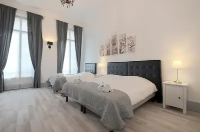 a large bedroom with two beds and windows at Residence Michel Ange in Cannes