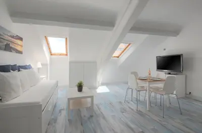a white living room with a white couch and a table at Residence Michel Ange in Cannes