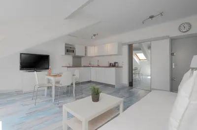 a white kitchen and living room with a table and chairs at Residence Michel Ange in Cannes