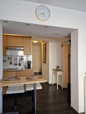 a kitchen with a table and a clock on the wall at Bright apartment 10 minutes from Cannes in Le Cannet