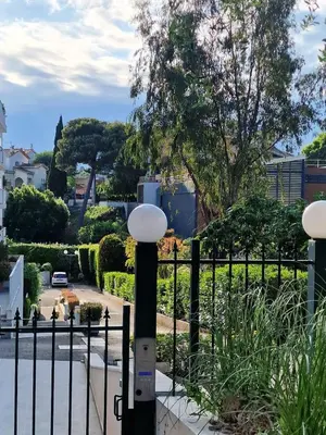 a black fence with two white lights next to a street at Bright apartment 10 minutes from Cannes in Le Cannet