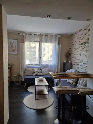 a living room with a couch and a table at Bright apartment 10 minutes from Cannes in Le Cannet