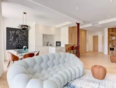 a large white couch in a living room with a kitchen at Luxury Apt Cannes Croisette sea view with terrasse in Cannes