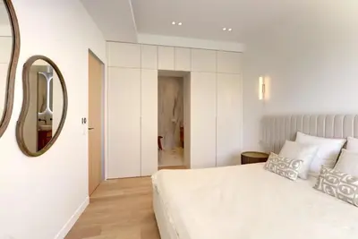 a bedroom with a large white bed and a mirror at Luxury Apt Cannes Croisette sea view with terrasse in Cannes