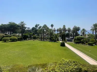a park with green grass and palm trees at Luxury Apt Cannes Croisette sea view with terrasse in Cannes