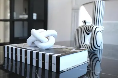 a stack of books on a table next to a vase at C023 Magnifique appartement 3 chambres dans Cannes in Cannes