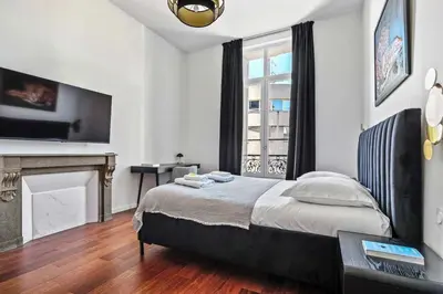 a bedroom with a large bed and a fireplace at C023 Magnifique appartement 3 chambres dans Cannes in Cannes
