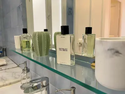 a glass shelf with perfumes on it in a bathroom at Villa Faustina by Connexion in Cannes