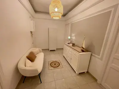 a bathroom with a toilet and a chair in a room at Villa Faustina by Connexion in Cannes