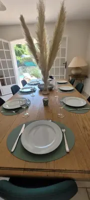 a wooden table with white plates and silverware on it at Villa Olimp in Super Cannes with sea view in Le Cannet