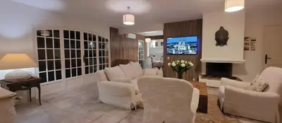 a waiting room with white chairs and a flat screen tv at Villa Olimp in Super Cannes with sea view in Le Cannet