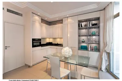 a kitchen with a glass table and white cabinets at REF 961 - Cannes Croisette - Sea view apartment for rent in Cannes
