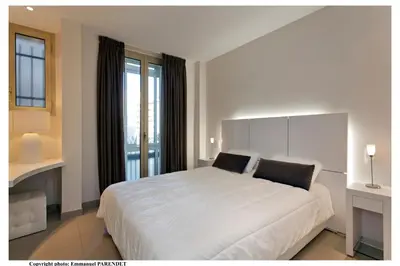 a white bedroom with a large bed and a window at REF 961 - Cannes Croisette - Sea view apartment for rent in Cannes