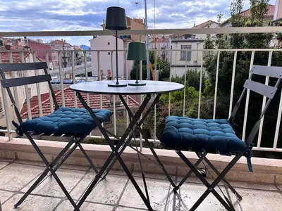 two chairs and a table on a balcony at Studio rénové marche Forville Cannes in Cannes