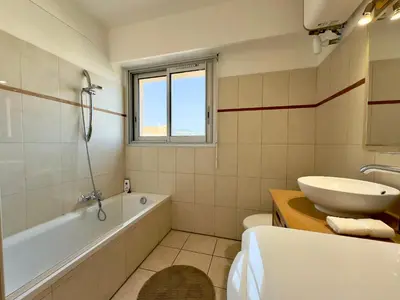 a bathroom with a tub and a sink and a toilet at Cannes Eden By SCLS Locations in Cannes