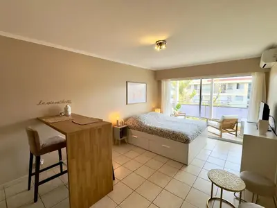 a bedroom with a bed and a desk and a kitchen at Cannes Eden By SCLS Locations in Cannes