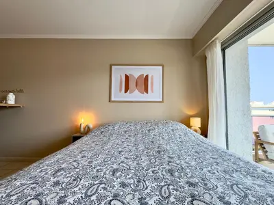 a large bed in a room with a window at Cannes Eden By SCLS Locations in Cannes