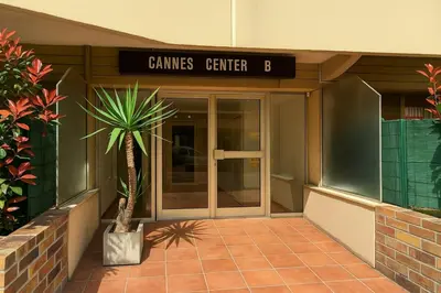 a building with a palm tree in front of a door at Studio cosy Cannes centre in Cannes