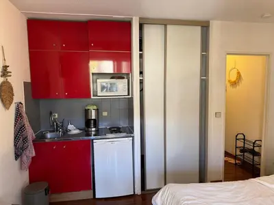 a small kitchen with red cabinets and a microwave at Studio cosy Cannes centre in Cannes