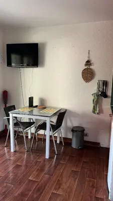 a dining room table with chairs and a television on a wall at Studio cosy Cannes centre in Cannes