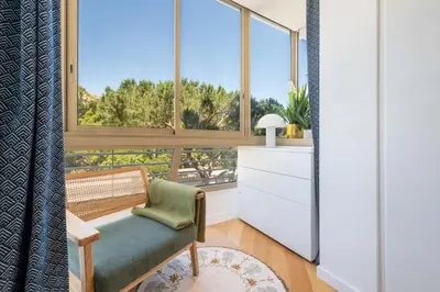a living room with a bench and a large window at 2-Br Apartment with Sea View Terrace Cannes in Cannes