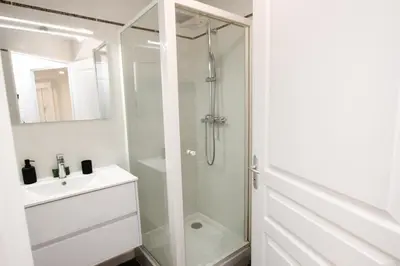 a white bathroom with a shower and a sink at Paradisio in Cannes
