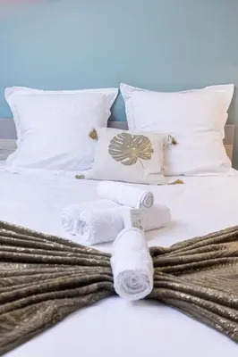 a white bed with towels and pillows on it at Bulle d'Azur - 10mn from Palais&Beaches, air conditioning, center in Cannes