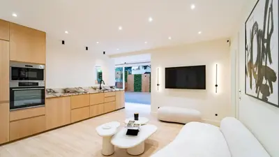 a living room with a white couch and a tv at 3BDR Cocoon in Cannes Martinez avec Jardin Privé & Design Contemporain à 5 min de la Croisette in Cannes